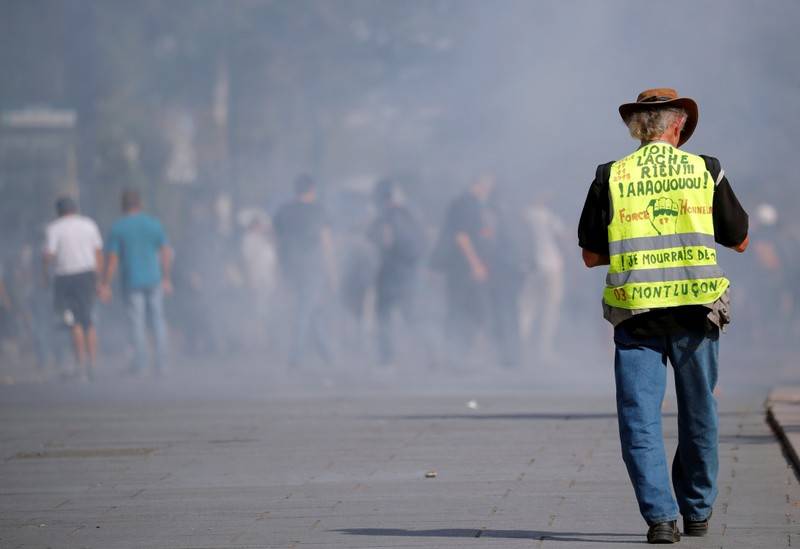 A protester wearing a yellow vest walks among tear gas as protesters clash with French riot police during a demonstration on Act 44 the 44th consecutive national protest on Saturday of the yellow vests movement in Nantes France September 14 2019. REUTERSStephane Mahe