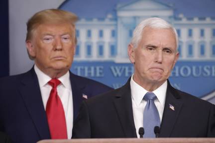 President Donald Trump, left, listens to Vice President Mike Pence, right, as he pauses while speaking to members of the media to address the nation about the coronavirus threat in the Brady Press Briefing room of the White House in Washington, Saturday, Feb. 29, 2020. (AP Photo/Carolyn Kaster)